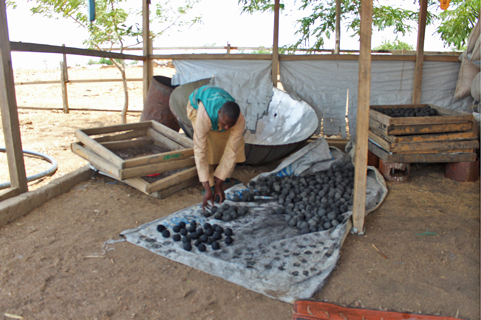 A man arranges eco-charcoal briquettes in the camp.