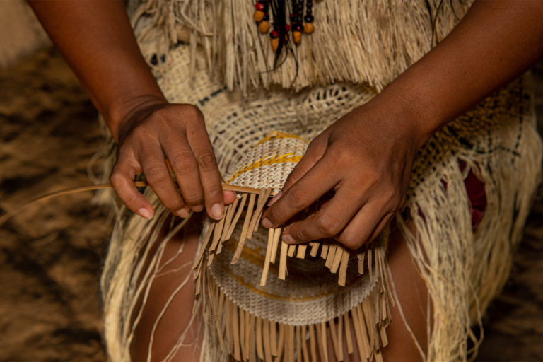 An Indigenous woman from the Colombian Amazon weaving a basket.