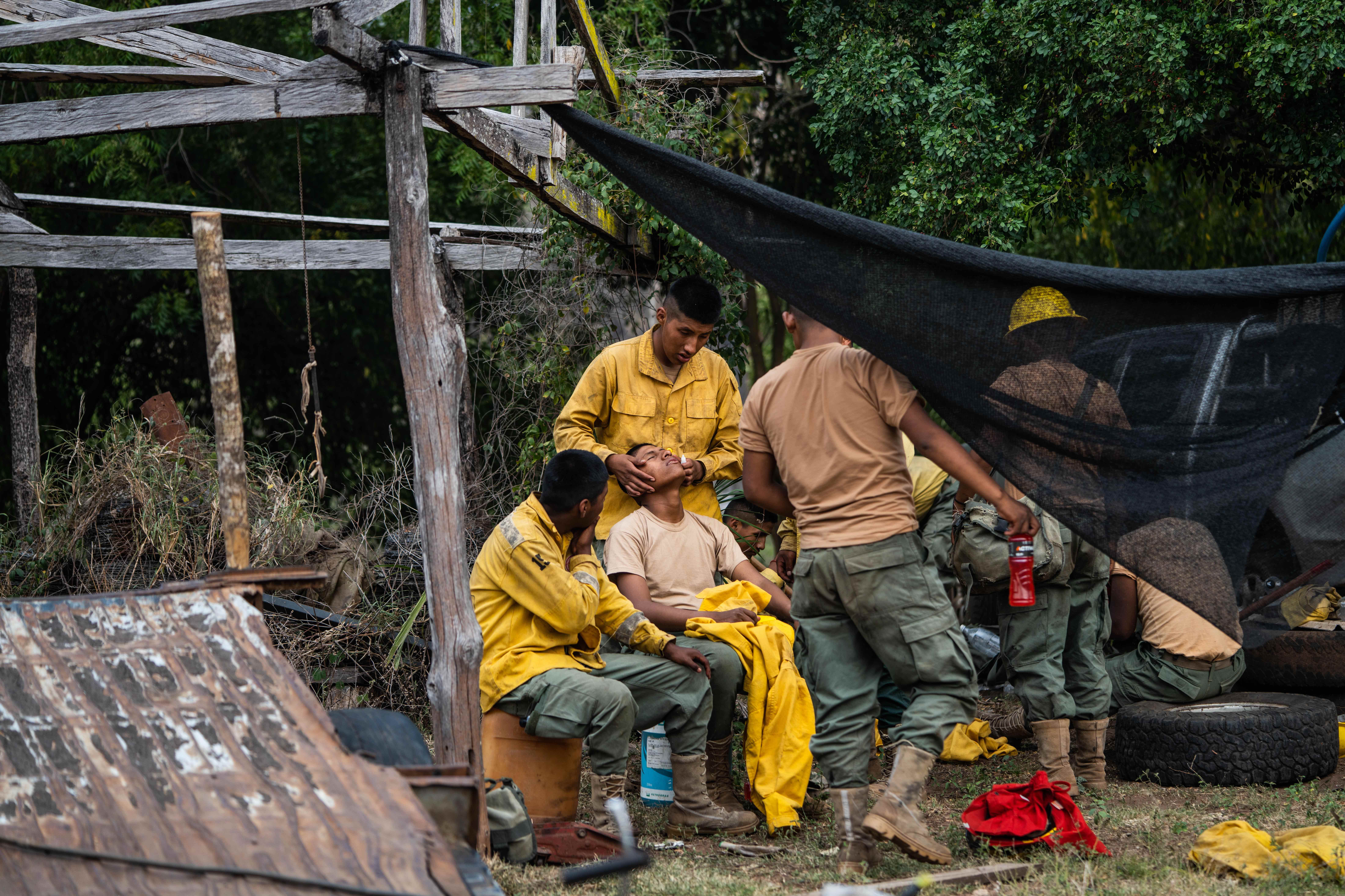 Firefighters rest and receive medical attention after hours of tackling forest fires in the municipality of Roboré. Image by Claudia Belaunde.