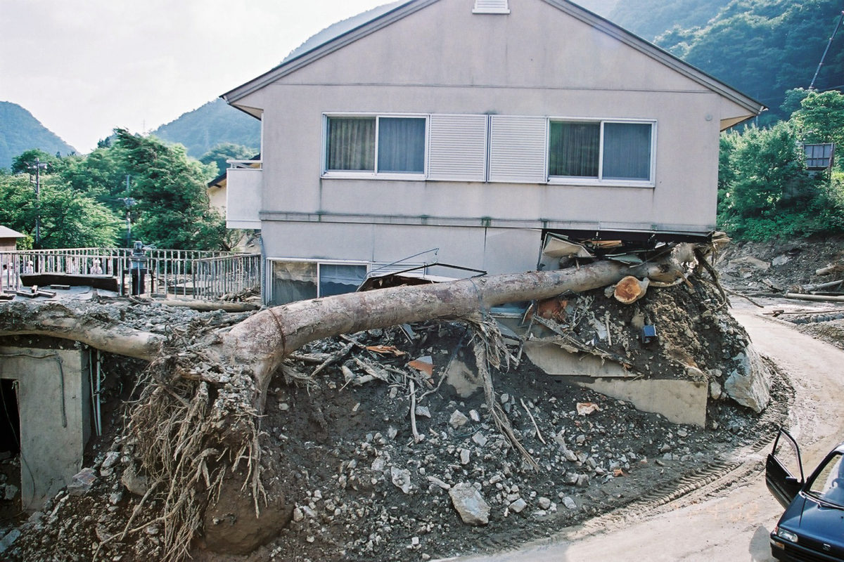 A building damaged by a tree swept away in a landslide.