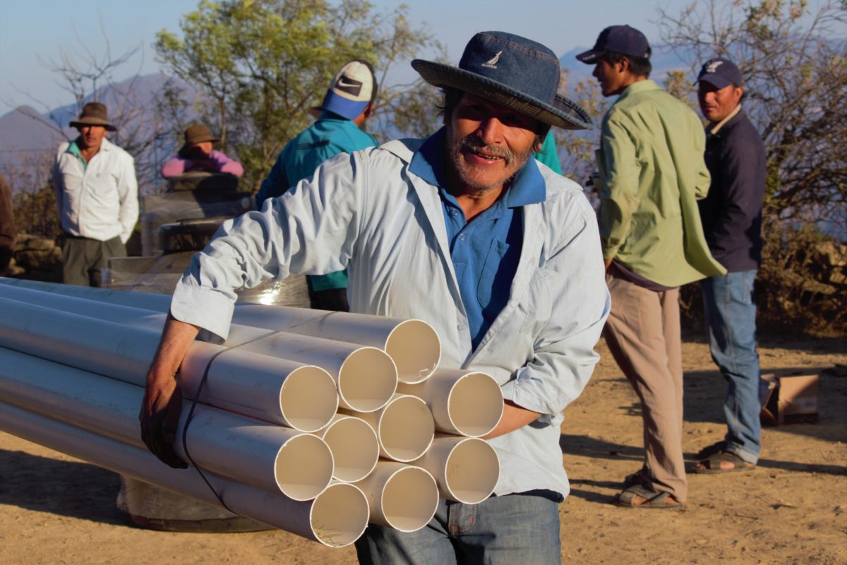 A man carrying pipes.