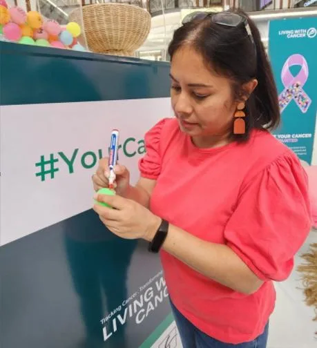 Ayesha-Sewbaran-Gateway-Centre-Management-Writing-the-name-of-her-tribute-as-a-remembrance-at-the-Your-Cancer-Counts-Statue-scaled Ayesha Sewbaran Gateway Centre Management Writing the name of her tribute as a remembrance at the Your Cancer Counts Statue.