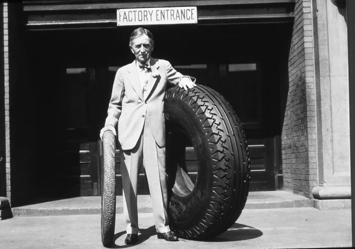 Harvey-Firestone-Sr.-with-original-Firestone-non-skid-tire-and-large-tire_Akron-Factory_1926-1930 Harvey Firestone Sr. with original Firestone non skid tire and large tire - Akron Factory 1926 - 1930
